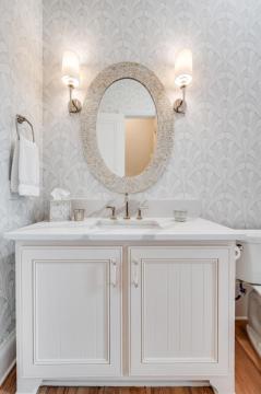 bathroom with white wooden vanity and patterned wallpaper