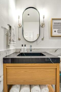 wooden bathroom vanity with black countertop