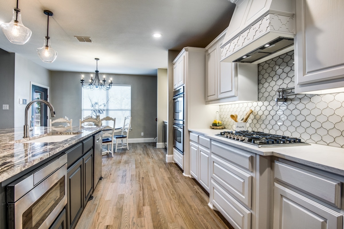 home makeover mistakes - grey and white remodeled kitchen with island and wood floors