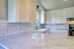 kitchen features worth the investment - white updated kitchen with subway tile backsplash