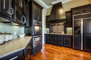 kitchen cabinets - kitchen with dark cabinetry and wood floors