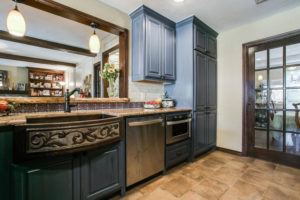 kitchen design trends - kitchen with dark blue cabinets and statement sink