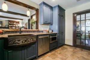 kitchen design trends - kitchen with dark blue cabinets and statement sink